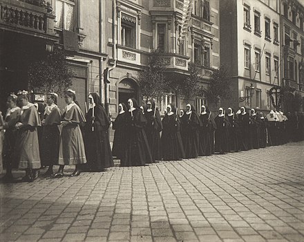 Nuns at a procession in 1915. The postulants in their garbs are walking in front of the professed nuns.