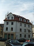 Tenement house with fencing and entrance gate, in a corner and open development