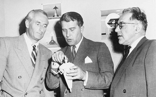 Von Braun holds a model of a bottle-suit also called a single person spacecraft