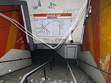 Interior of the disused Essex Street entrance, with a 1977 map and parts of the original gray tile mosaic visible Interior of former Essex Street entrance to Chinatown station, July 2019.JPG