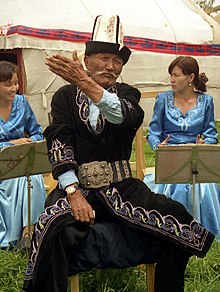 A traditional Kyrgyz manaschi performing part of the Epic of Manas at a yurt camp in Karakol Kyrgyz Manaschi, Karakol.jpg