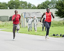 Malavi Olimpiya marafoni yuguruvchisi Mayk Tebulo chap tomonga Buyuk Britaniya qurolli kuchlari Lance Cpl bilan marraga etib boradi. Frensis Okumu, Ittifoqning tezkor reaktsiya korpusi (ARRC) bilan, Imjin barakasida, Innsvort 120712-O-ZZ999-003.jpg