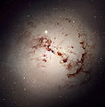 NGC 1316, soczewkowata galaktyka poprzecinana ciemnymi pasmami.