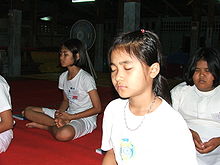 Although women in Thailand traditionally cannot ordain as bhikkhuni, they can choose to take part in quasi-monastic practices at temples and practice centers as maechi. Thai Buddhist child is sitting the concentration happily.jpg