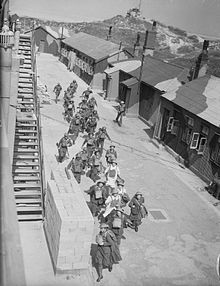 ATS girls and gun crews of 177 Heavy Battery Royal Artillery rush to 'take post' at Fort Crosby near Liverpool, England. This training operation formed part of British preparations to repel the threatened German invasion of 1940 (IWM H2696) The British Army in the United Kingdom 1939-45 H2696.jpg