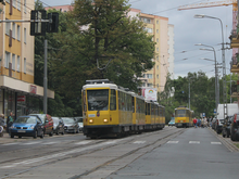 Zdjęcie. Na pierwszym planie tramwaje Tatra T6A2D w składzie dwuwagonowym. Tuż za nimi skład dwuczłonowych Tatr KT4DtM. Na torze do jazdy w przeciwnym kierunku, na wysokości dwuskładu Tatr KT4DtM inny skład Tatr T6A2D. Za tramwajami zieleń i wieżowce mieszkalne. Na lewo od tramwajów kamienice.