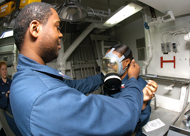 File:US Navy 060322-N-1693W-016 Yeoman 3rd Class Robert Russ helps Yeoman 2nd Class Latia Latimore adjust the straps on an MCU-2P gas mask during a Chemical, Biological, and Radiological (CBR) general quarters drill.jpg
