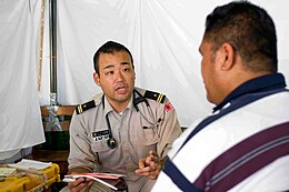 US Navy 090707-N-9689V-005 Japan Maritime Self Defense Force Lt. Kei Mikita consults locals suffering from joint pain or skin conditions at a Pacific Partnership 2009 Medical Civic Action Project.jpg