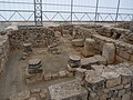 Baptisteri (C), als peus de la basílica. La piscina baptismal és al centre, coberta de terra.