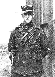 Half portrait of man in military uniform with kepi, outdoors