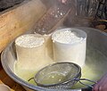 The curds are poured into pierced molds.