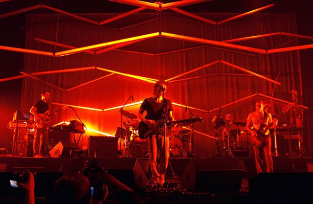 Atoms for Peace performing in 2010. From left to right: Nigel Godrich, Thom Yorke, Flea, and Mauro Refosco (obscured behind Flea, Joey Waronker behind