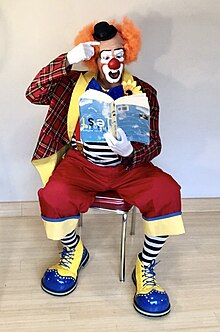 Auguste clown reading a book upside-down.jpg