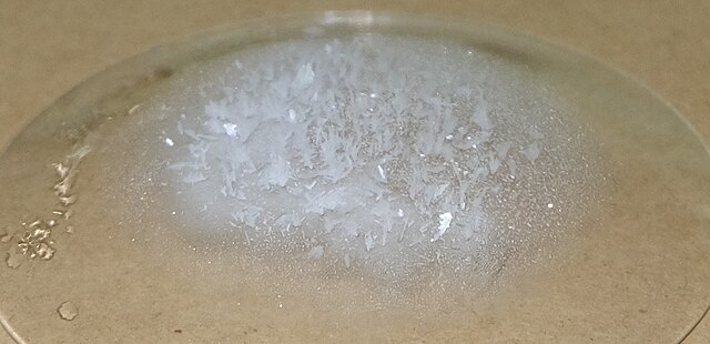 Solid compound of naphthalene sublimed to form a crystal-like structure on the cool surface.