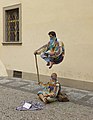 Pouliční umělci levitují v Karlově ulici, ve skutečnosti horní osobu drží skrytá konstrukce