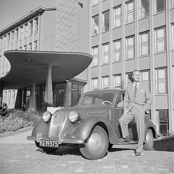 File:De heer de Visser staand voor zijn Simca 8 voor het KLM hoofdgebouw in Den Haag, Bestanddeelnr 255-8953.jpg