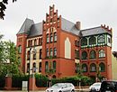 Katholische Kirche St. Johannes Baptist (Nr. 1) einschließlich Einfriedung und katholisches Gemeindehaus (Nr. 2) mit Vorgarten und zugehöriger Einfriedung