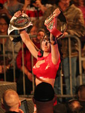 Gail Kim, a seven-time TNA Knockouts Champion (right hand), held the TNA Knockouts Tag Team Championship simultaneously Gail Kim TNA CHAMP.jpg