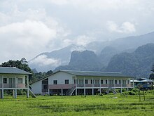 A government sponsored longhouse in a Penan Village on the Melinau River, adjacent to Gunung Mulu National Park, Sarawak. Government longhouses (21379430402).jpg