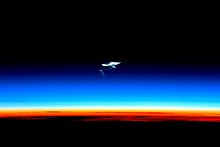 Afterglow of the troposphere (orange), the stratosphere (whitish), the mesosphere (blue) with remains of a spacecraft reentry trail, and above the thermosphere without a visible glow ISS-46 Soyuz TMA-17M reentry.jpg