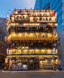 Fachada iluminada de um restaurante de três andares com painéis japoneses e lanternas de papel vermelhas, no distrito comercial Yurakucho, Chiyoda, Tóquio, Japão (definição 3 762 × 4 559)