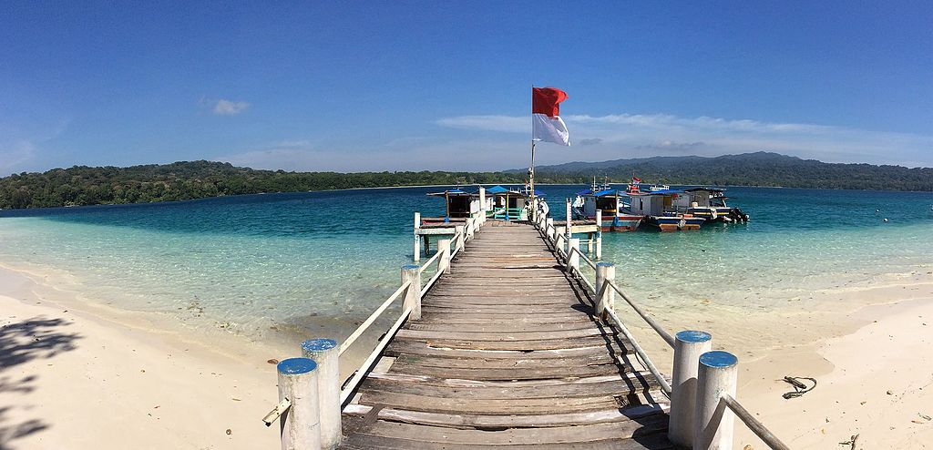 Nationalpark Ujung Kulon: Blick südostwärts über Landungssteg und Strand der Insel Peucang auf die Halbinsel Ujung Kulon (UNESCO-Weltnaturerbe in Indonesien).Peucang island, Banten