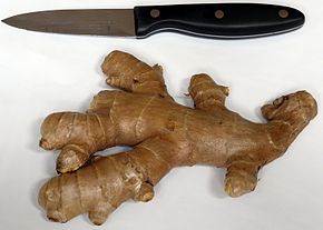 an unpeeled ginger root beside a small knife