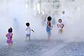 Kids playing in artificial fog at Osaka Station open space; July 2013.jpg