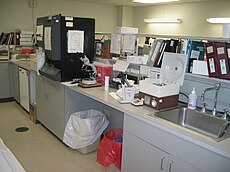 Laboratory equipment for hematology (black analyser) and urinalysis (left of the open centrifuge). LabEquipment.jpg