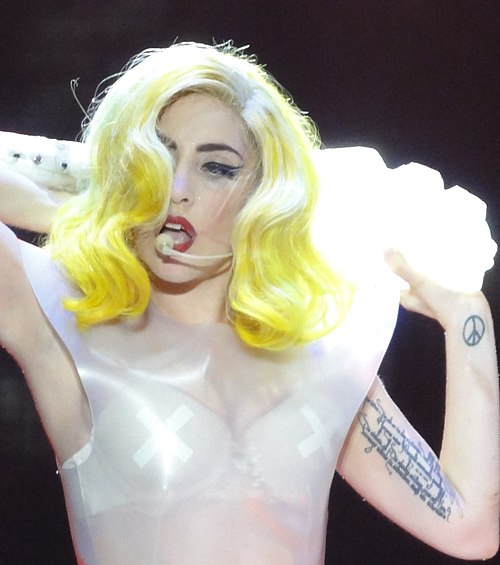 The tattoo on Gaga's left biceps displays the date her aunt Joanne died between lines from a poem by Rainer Maria Rilke.