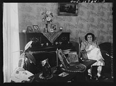 Mrs. R.W. Elizabeth Almoney in her living room, with pictures of her relatives in the service