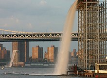 Waterfall under the Brooklyn Bridge. The bridge in the background is the Manhattan Bridge.