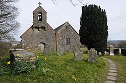 Doppelgiebelkirche mit Glockenturm und Friedhof im Vordergrund