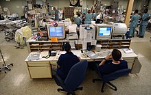 ICU nurses monitoring patients from a central computer station. This allows for rapid intervention should a patient's condition deteriorate whilst a member of staff is not immediately at the bedside. US Navy 030423-N-6967M-090 A central computer system monitors the heart rates of each patient in the Intensive Care Unit (ICU) to ensure a quick.jpg