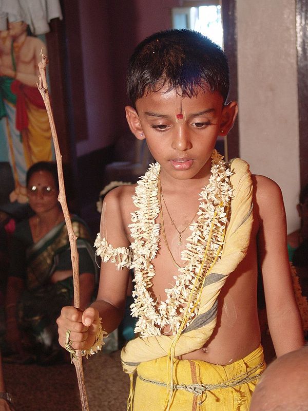 South India. A boy during his upanayana ritual. The thin, yellow yajnopavita thread runs from left shoulder to waist. Note the muñja grass girdle arou