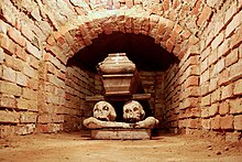 Image représentant une crypte en Pologne avec un cercueil posé sur deux crânes et un livre.