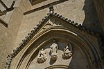 Le fronton du portail avec des statues : au centre de l'Immaculée Conception et de chaque côté un ange tenant un manuscrit où est écrit en latin : à gauche " Maria Virgo " (Vierge Marie) et à droite un autre message.