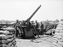 3-inch HAA gun of AA Command, 1940. 3-inch gun crew of 303rd Battery, 99th Anti-Aircraft Regiment, Royal Artillery, in action at Hayes Common in Kent, May 1940. H1388.jpg