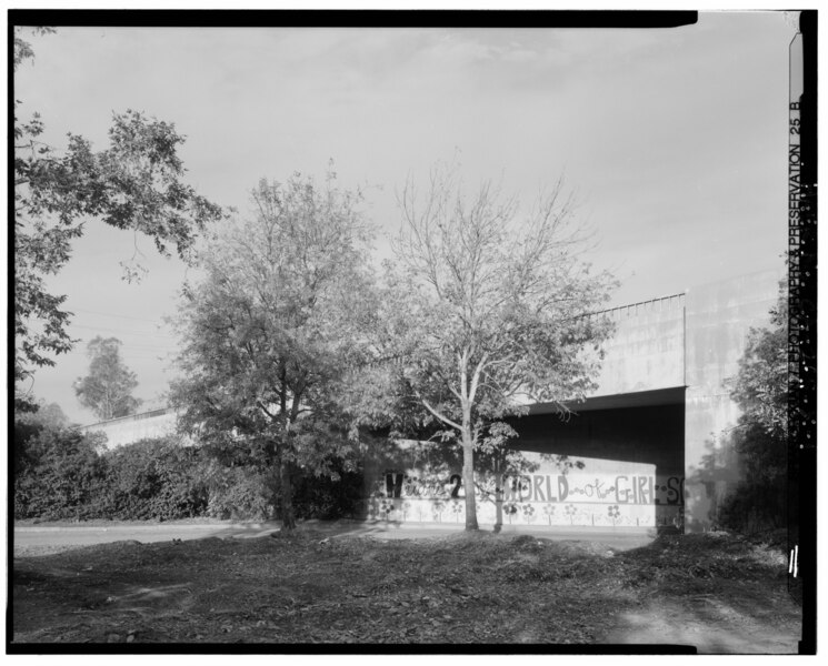 File:ARROYO SECO PARKWAY OVERCROSSING OF ARROYO SECO CHANNEL. CHANNEL IS BEHIND TREES AND BUSHES AT RIGHT AND LEFT. STONEY DRIVE PASSES UNDER PARKWAY. LOOKING 282°W - Arroyo HAER CAL,19-LOSAN,83X-1.tif