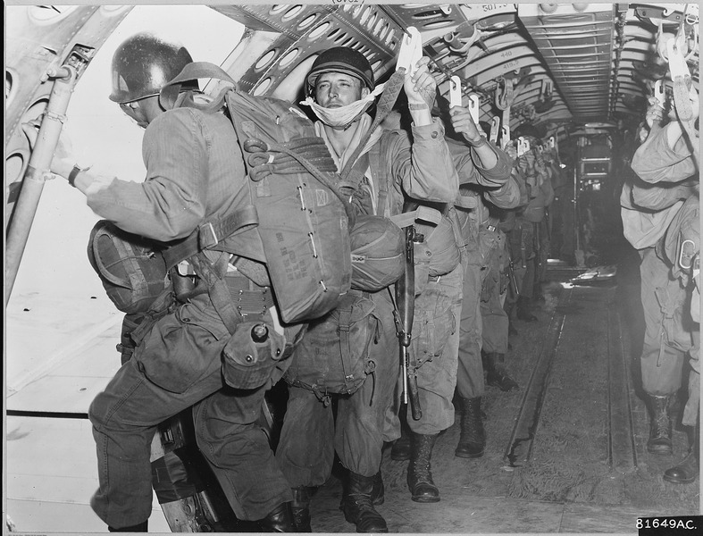 File:About to step into thin air, a paratrooper of the 187th Regimental Combat Team pauses momentarily while the man below... - NARA - 542244.tif