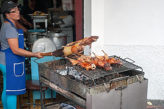 Asando cuy a la brasa a la puerta de una tienda en Baños (Ecuador)