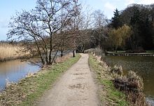 Damm zwischen der Schwartau (links) und dem Schwartauer See (rechts) – im Hintergrund die Brücke über die Verbindung (aus Westen)