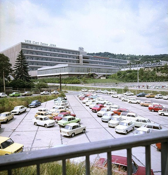 574px-Bundesarchiv_Bild_183-T0709-429%2C_VEB_Carl_Zeiss_Jena%2C_Geb%C3%A4udeansicht%2C_Parkplatz.jpg