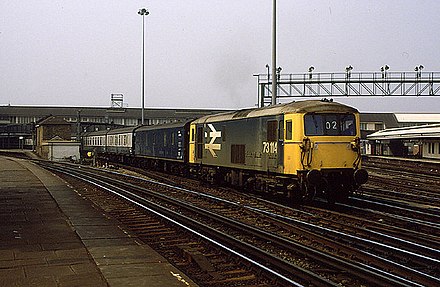 A British Rail Class 73 with a parcels van and carriages under British Rail carrying the mail in 1986 through Clapham Junction.