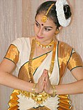 Dansar med bindi kledd i sari. Ho utfører ein namaskaram (namaste)