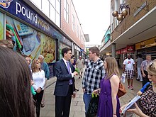 Ed Miliband talks to a local couple whilst campaigning in Crawley during the run up to elections Ed Miliband (14208785685).jpg