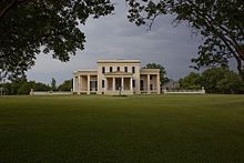 The front elevation, showing the porte-cochere of the main entrance, side porticoes, the flanking parterre walls, as seen from the front allee. Gaineswood by Highsmith 001.jpg