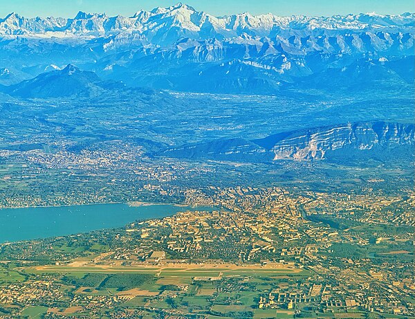 The Geneva area seen from above the Jura mountain chain, with the International airport in the foreground, and the Mont Blanc mountain range in the ba