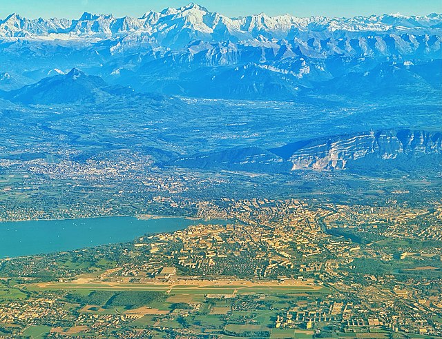 The Geneva area seen from above the Jura mountain chain, with the International airport in the foreground, and the Mont Blanc mountain range in the ba