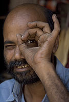 Indian man peeking through a hole Varanasi Benares India